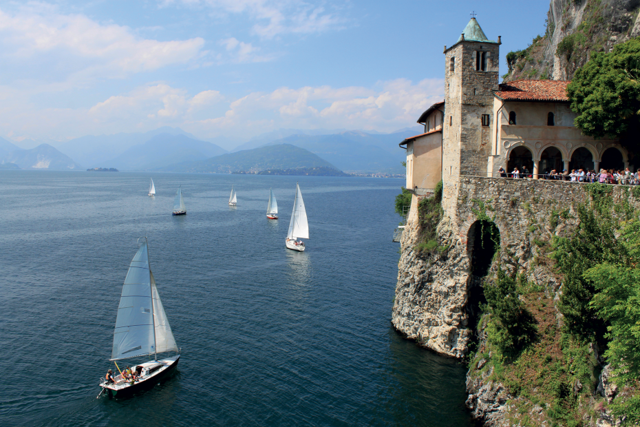 Eremo di Santa Caterina del Sasso che si affaccia sul Lago Maggiore. Nel lago navigano delle barche a vela.