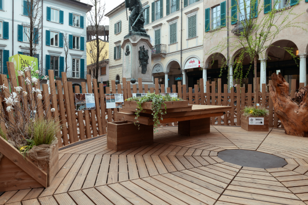 Installazione in legno dal titolo "Nido" in Piazza del Podestà per la Varese Design Week. La piattaforma in legno installata nella piazza ospita arredi, panchine e tronchi.